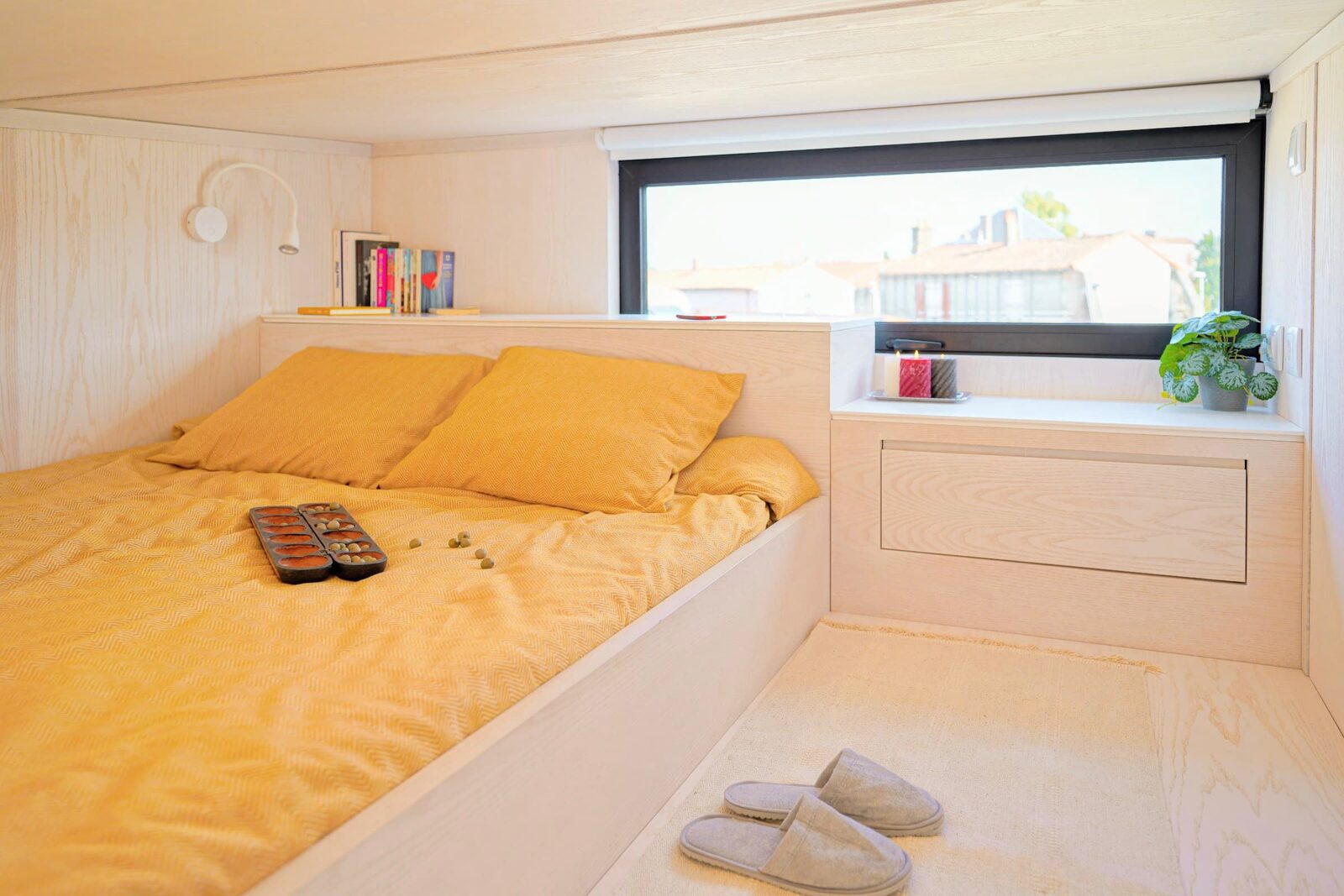 Couchage en mezzanine d'un module Hoummi, fenêtre bandeau et rangements intégrés