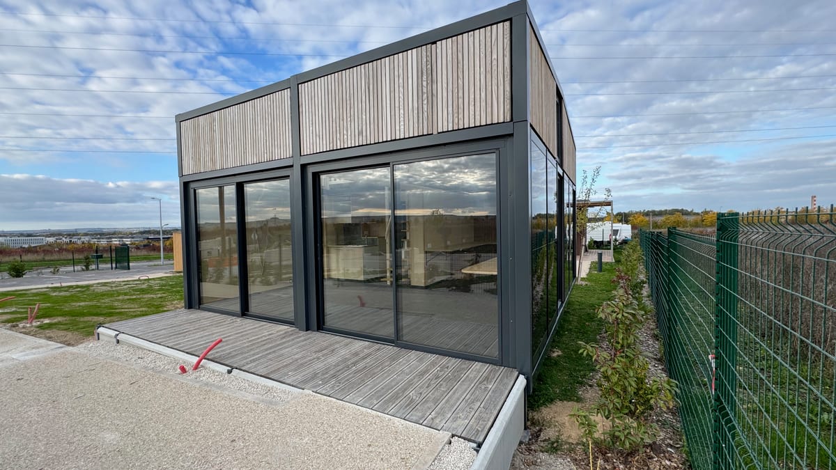 Module Hoummi posé sur son terrain, platelage de terrasse en cours de pose devant la façade vitrée